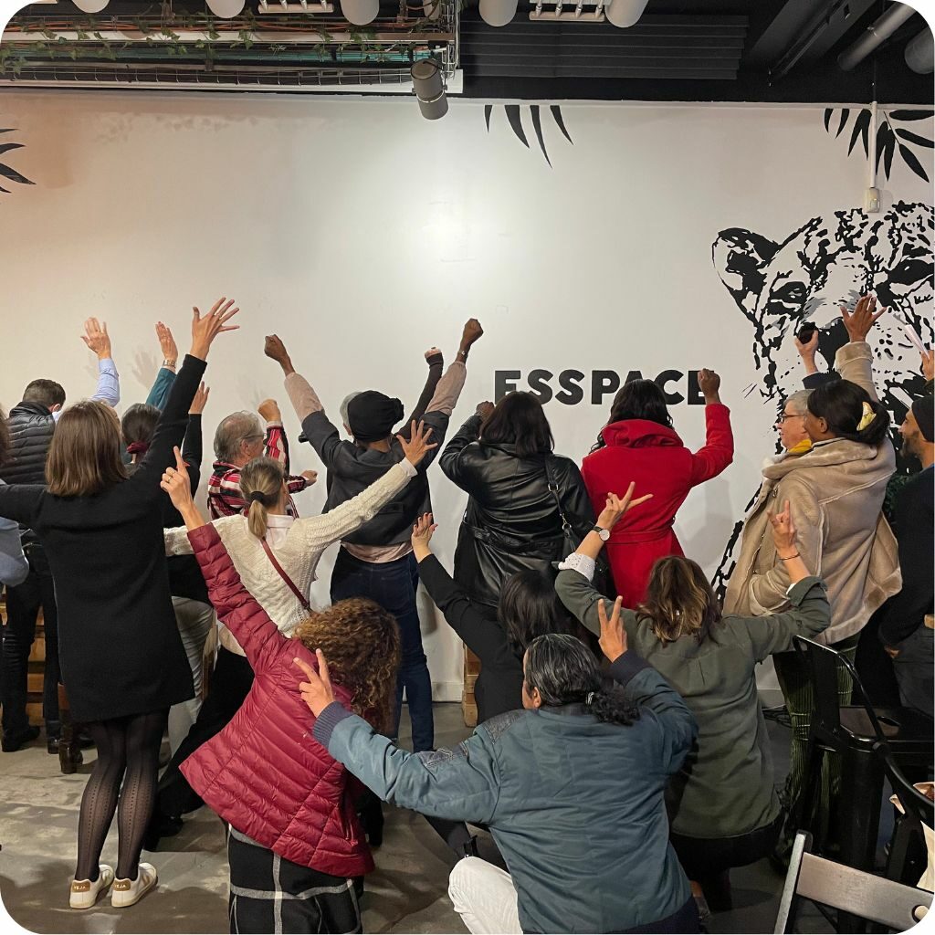 Groupe de personnes de dos qui lèvent les mains en l'air