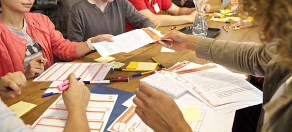 Photo de distribution de feuilles lors d'un atelier collaboratif