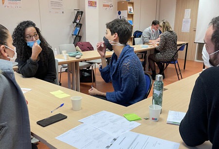 Photo lors d'une formation. La formatrice échange avec les stagiaires